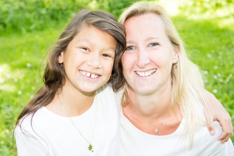 Blonde caucasienne de jeune mère mélangée heureuse de famille avec la fille sud-américaine indienne image stock Blonde caucasienne de jeune mère mélangée heureuse de famille avec la fille sud-américaine indienne image stock