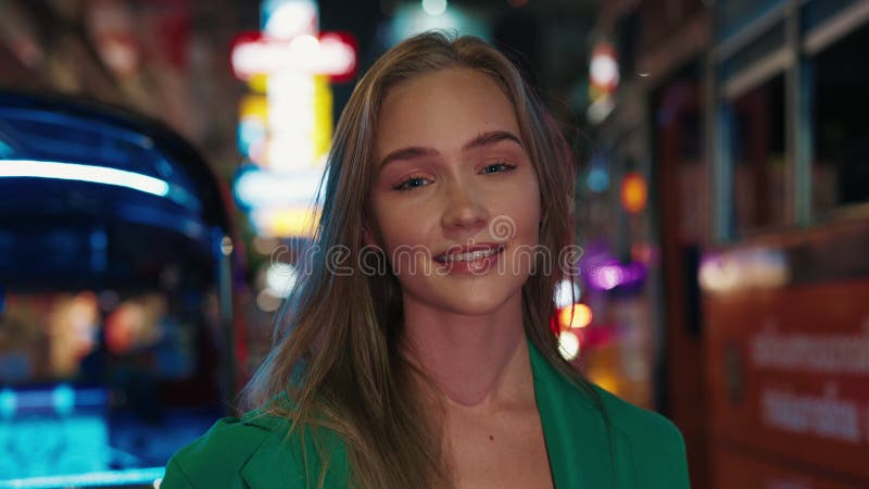 Blonde caucasienne en veste verte debout dans la rue de la ville de nuit clips vidéos