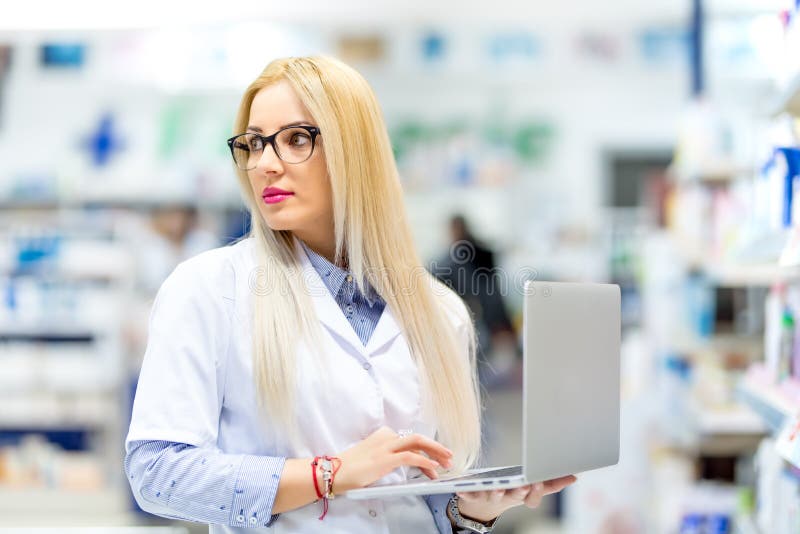 Blonde doctor, young pharmacist searching for prescription drugs on laptop. Pharmacy woman using modern technology stock images Blonde doctor, young pharmacist searching for prescription drugs on laptop. Pharmacy woman using modern technology stock images