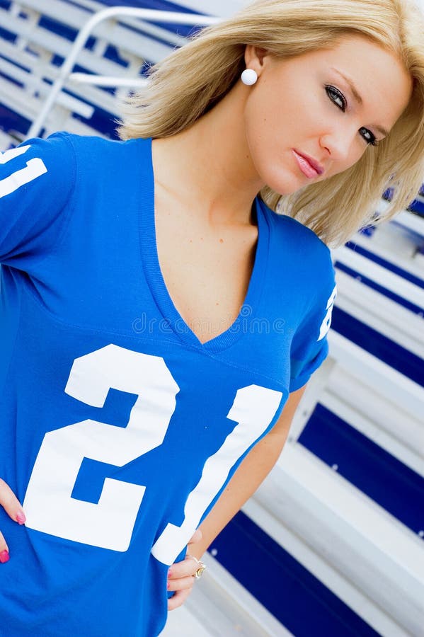 Blonde female / woman / girl / lady fashion model in blue football jersey. Blonde female / woman / girl / lady fashion model in blue football jersey