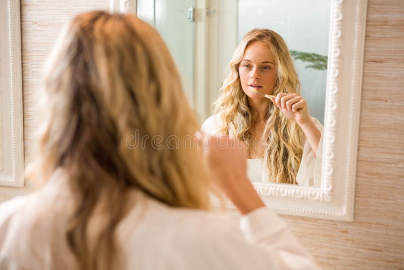Blonde Frau, die ihre Zähne putzt stockbilder Blonde Frau, die ihre Zähne putzt stockbilder