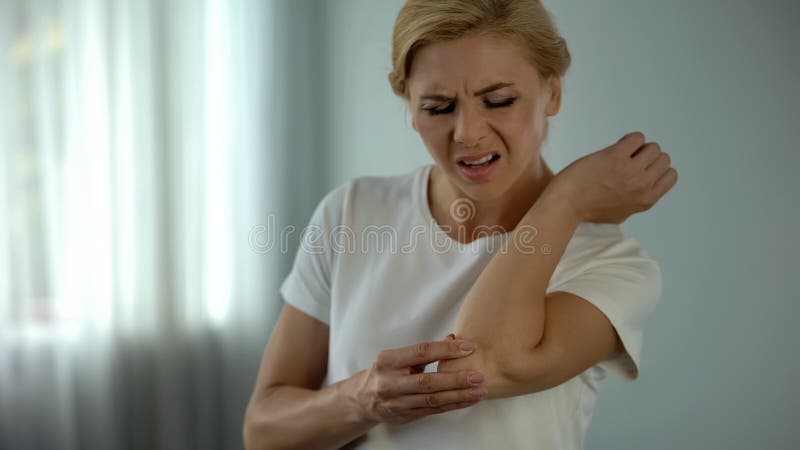 Blonde Frau, die unter den Ellbogenschmerz, ihren schmerzenden Arm, Verletzung und Klammer halten leidet stockfoto Blonde Frau, die unter den Ellbogenschmerz, ihren schmerzenden Arm, Verletzung und Klammer halten leidet stockfoto