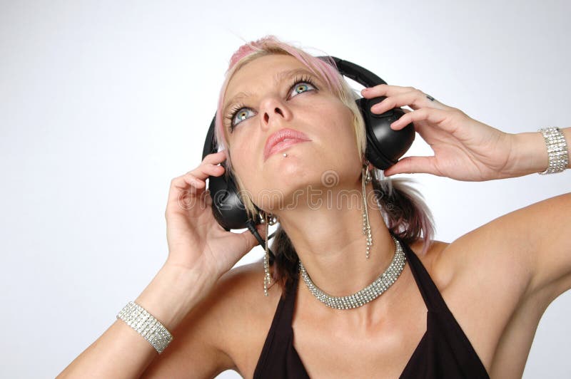 Blond enjoying music with headphones on a neutral background. Blond enjoying music with headphones on a neutral background