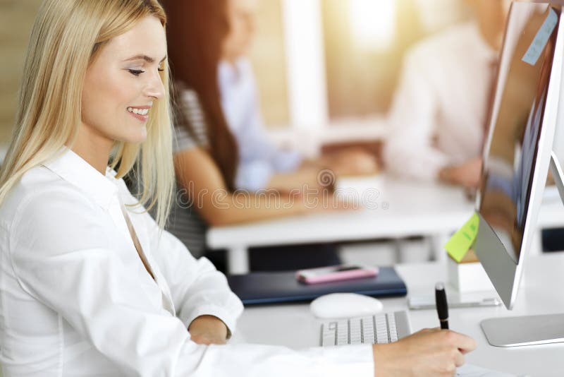 Blonde Geschäftsfrau mit Computer am Arbeitsplatz im sonnigen Büro. Arbeit für Freude und Erfolg lizenzfreie stockbilder