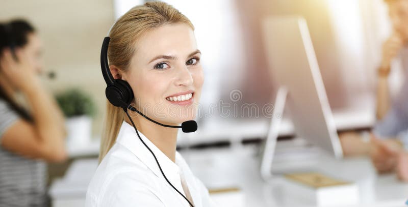 Blonde Geschäftsfrau mit Headset für Kommunikation und Beratung von Menschen im sonnigen Büro. Call Center lizenzfreies stockbild