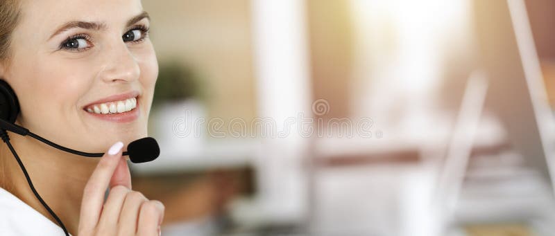 Blonde Geschäftsfrau mit Headset für Kommunikation und Beratung von Menschen im sonnigen Büro. Call Center stockfotografie