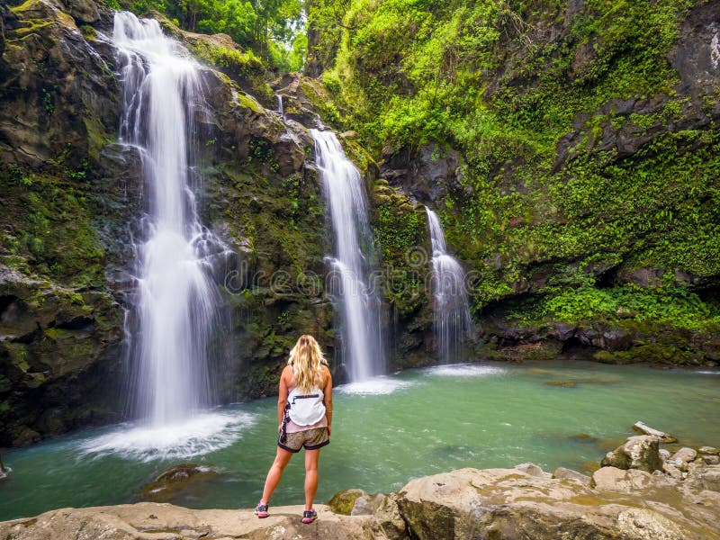 Blonde girl admires Three Bears Falls in Maui, Hawaii Hana Highway - Upper Waikani Falls. Road to Hana connects Kahului to the town of Hana Over 59 bridges, 620 curves, tropical rainforest. Blonde girl admires Three Bears Falls in Maui, Hawaii Hana Highway - Upper Waikani Falls. Road to Hana connects Kahului to the town of Hana Over 59 bridges, 620 curves, tropical rainforest.