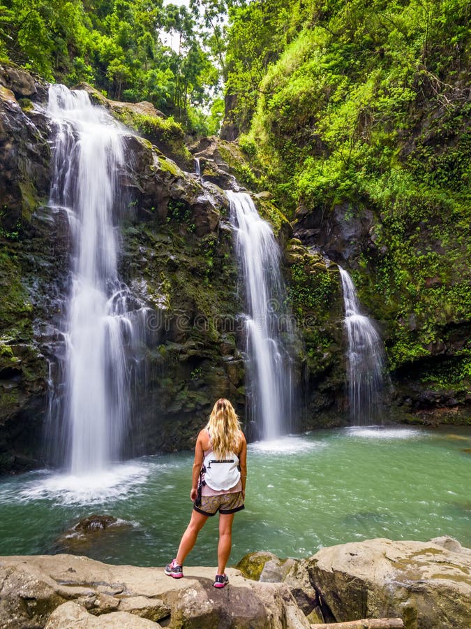 Blonde girl admires Three Bears Falls in Maui, Hawaii Hana Highway - Upper Waikani Falls. Road to Hana connects Kahului to the town of Hana Over 59 bridges, 620 curves, tropical rainforest. Blonde girl admires Three Bears Falls in Maui, Hawaii Hana Highway - Upper Waikani Falls. Road to Hana connects Kahului to the town of Hana Over 59 bridges, 620 curves, tropical rainforest.