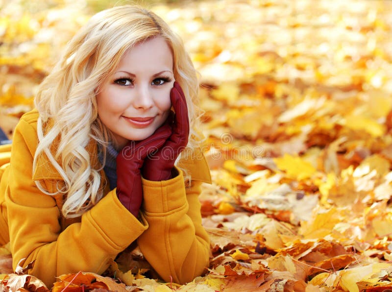 Ragazza bionda in Autunno il Parco con le foglie d'Acero.