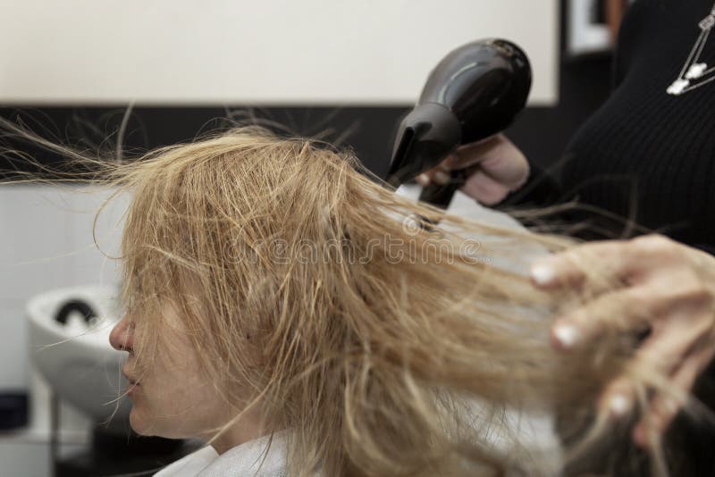 Blonde Girl in a Beauty Salon Blow Dry Her Hair. Close-up Stock Image ...