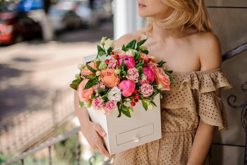 Blonde girl in beige dress with open shoulders holding a square royalty free stock photos Blonde girl in beige dress with open shoulders holding a square royalty free stock photos