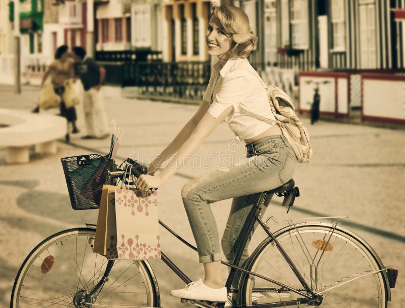 Blonde girl on bicycle in shopping time