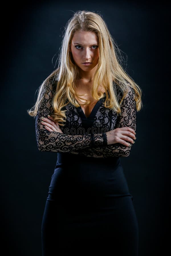 Blonde girl on a black background in dark guipure dress