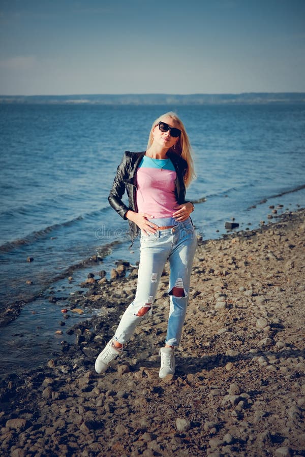 Blonde Girl In Black Glasses And Jeans Posing On The Beach Stock Photo,  Picture and Royalty Free Image. Image 119025249.