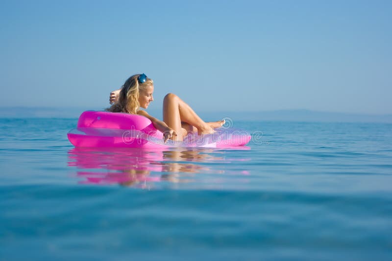 Blonde girl on inflatable raft royalty free stock photo