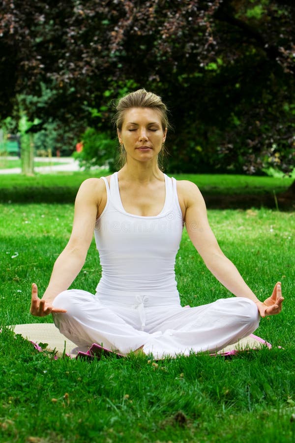 Blonde girl in park doing yoga