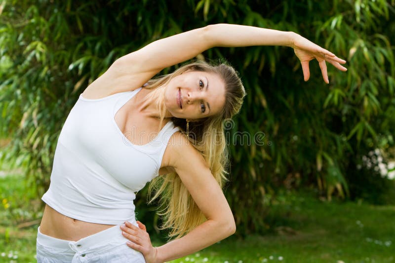 Blonde girl in park doing yoga