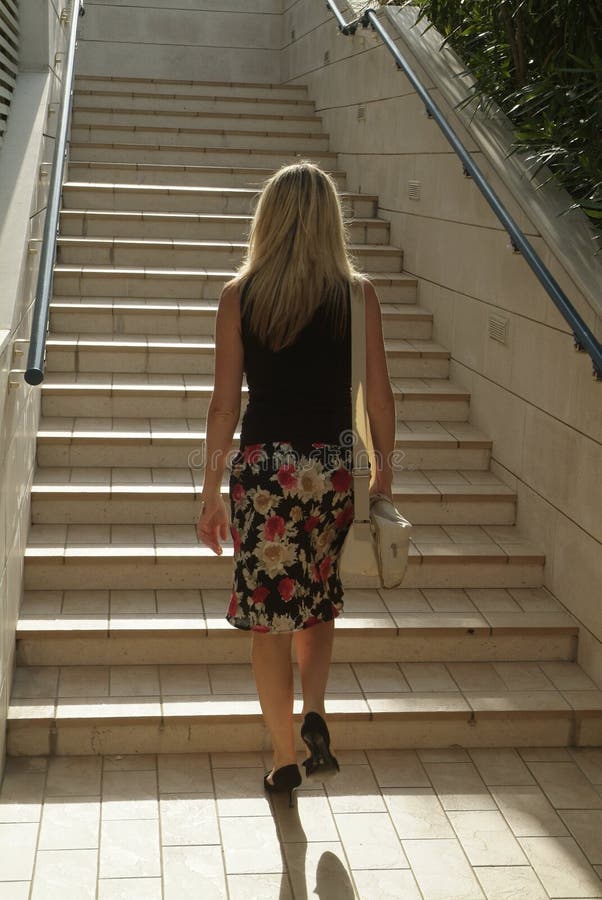 Blondýnka módní oblečený chůze na schodech.