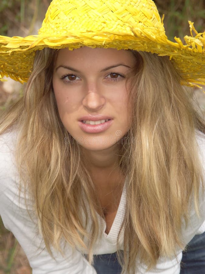 Blonde girl with yellow hat leaning forward