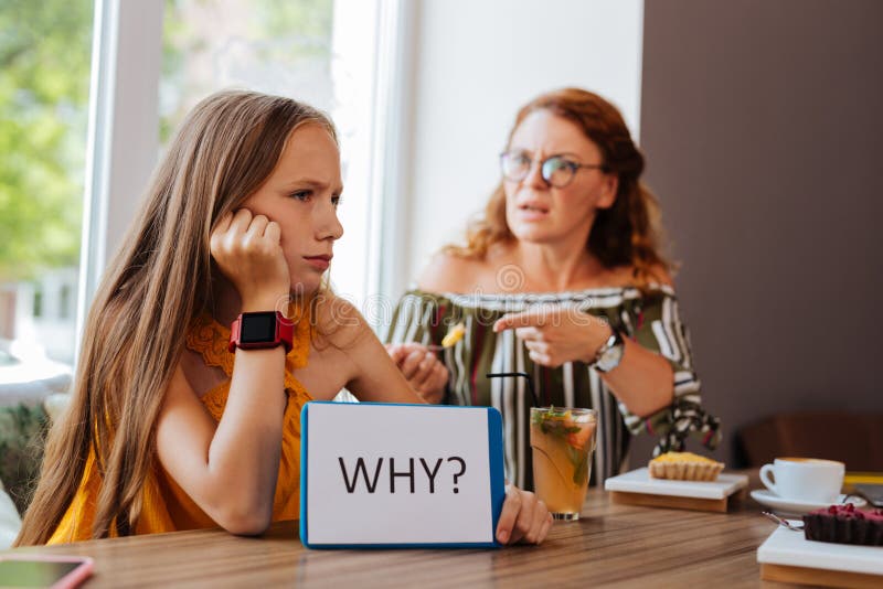 Blonde-haired meisje die met haar bezige moeder debatteren royalty-vrije stock afbeelding Blonde-haired meisje die met haar bezige moeder debatteren royalty-vrije stock afbeelding