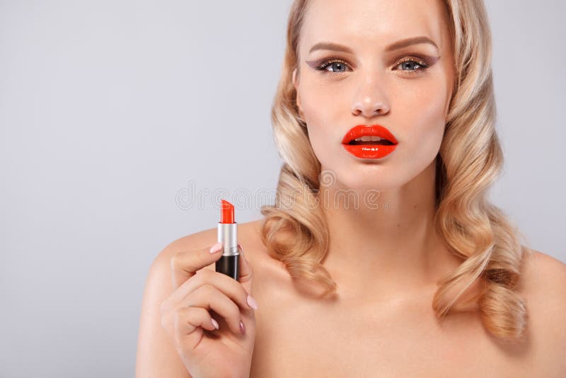 Blonde hermoso de una manera de Hollywood con los rizos, labios rojos, lápiz labial a disposición Cara y pelo de la belleza cosme fotos de archivo libres de regalías Blonde hermoso de una manera de Hollywood con los rizos, labios rojos, lápiz labial a disposición Cara y pelo de la belleza cosme fotos de archivo libres de regalías