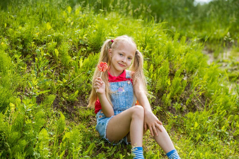 Blonde Little Girl with Long Hair and Candy on a Stick Stock Image ...