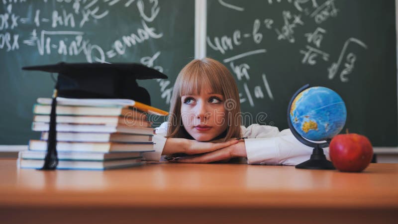 Blonde schoolgirl with bangs poses in front of school objects. stock images