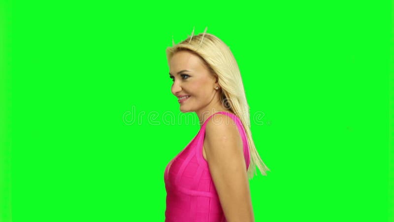 Blonde vrouw die, op chroma groene achtergrond dansen