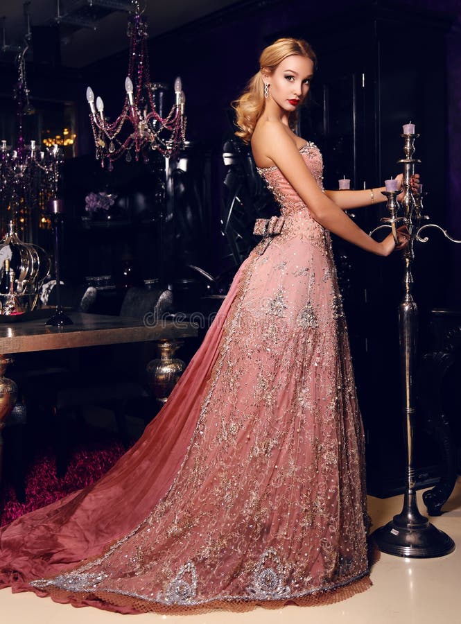 Blonde vrouw in het elegante lovertjekleding stellen in luxueuze binnenlands royalty-vrije stock afbeelding Blonde vrouw in het elegante lovertjekleding stellen in luxueuze binnenlands royalty-vrije stock afbeelding