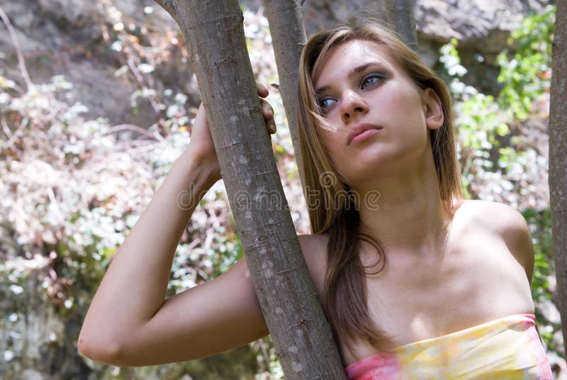 Blonde woman with blue eyes on a tree