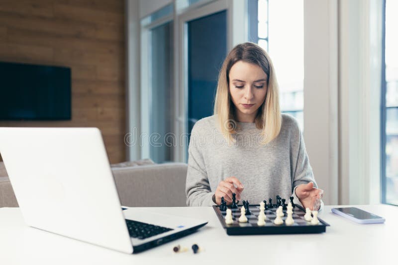 Blonde Woman Playing Chess Online Uses Laptop, Thoughtfully Makes