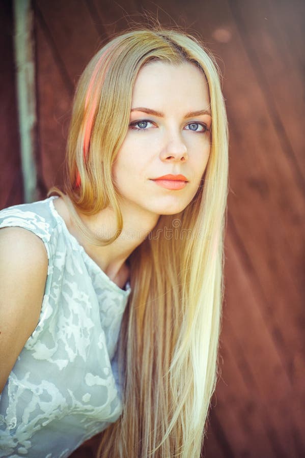 Blonde Woman on a Red Wooden Background Has Her Hair Painted in a Pink ...