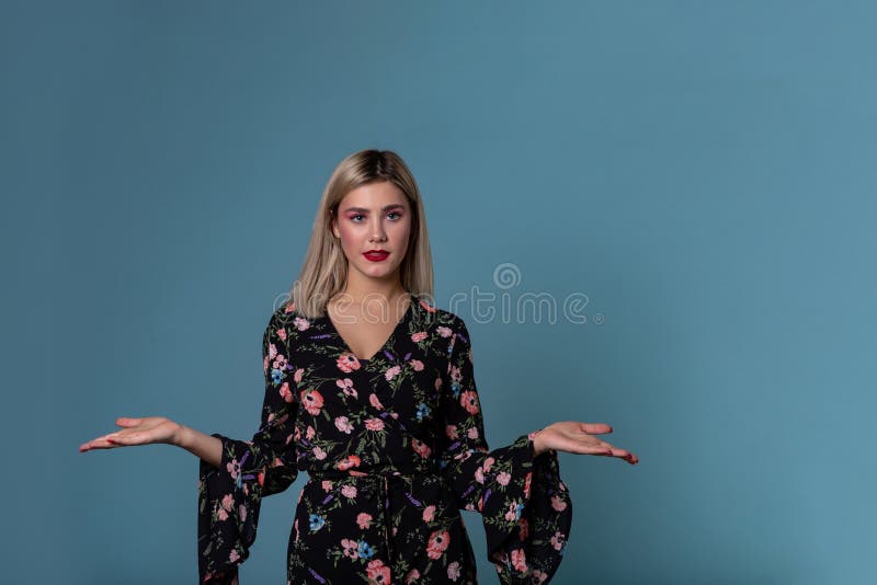 Blonde young woman in spring dress showing open palm with copy space for prodact royalty free stock images Blonde young woman in spring dress showing open palm with copy space for prodact royalty free stock images