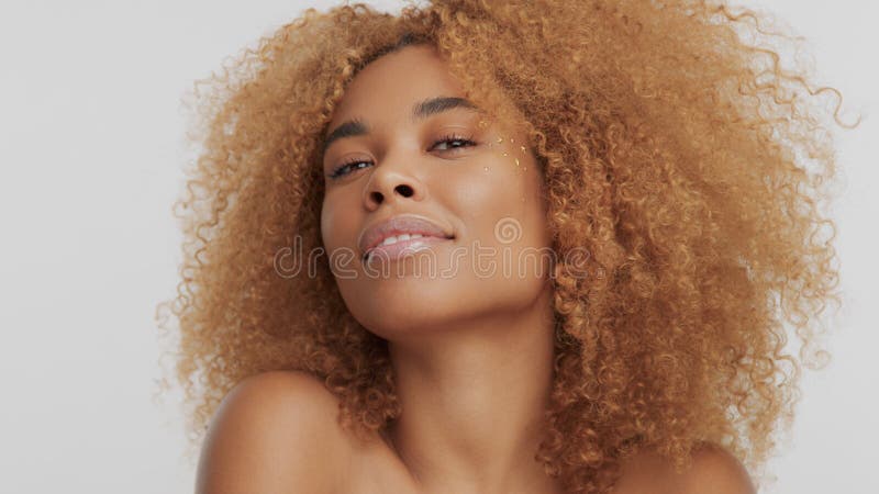 Mixed race black blonde model with curly hair with chin uo head watching to the camera. Mixed race black blonde model with curly hair with chin uo head watching to the camera