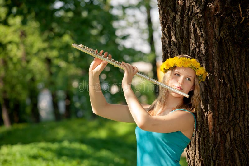 Blondes Mädchen, das Flöte im Park spielt stockfotos Blondes Mädchen, das Flöte im Park spielt stockfotos