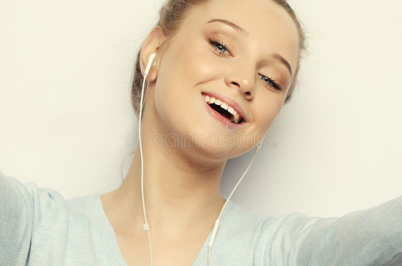 Blondes Mädchen in der hörenden Musik der Kopfhörer, die Foto macht stockfotografie Blondes Mädchen in der hörenden Musik der Kopfhörer, die Foto macht stockfotografie