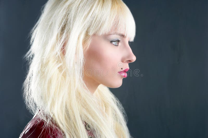 Blond young girl profile portrait over gray background. Blond young girl profile portrait over gray background
