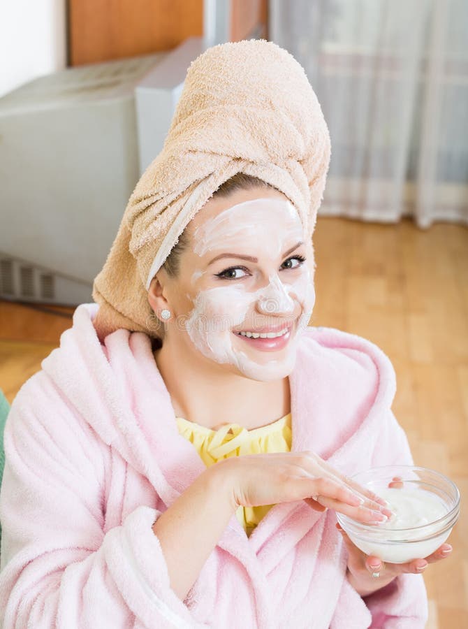 Blondin med ansiktsmask som inomhus kopplar av på soffan royaltyfria foton Blondin med ansiktsmask som inomhus kopplar av på soffan royaltyfria foton