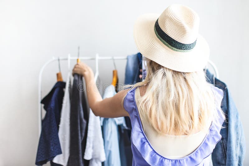 Blondy girl near a wardrobe with clothes can not choose what to wear stock photos Blondy girl near a wardrobe with clothes can not choose what to wear stock photos