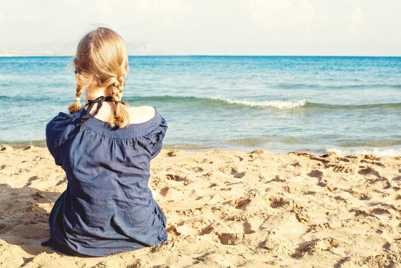 Blone flicka på tropisk strandsemester, kvinnlig baksida mot havet, sand och himmel royaltyfri fotografi Blone flicka på tropisk strandsemester, kvinnlig baksida mot havet, sand och himmel royaltyfri fotografi