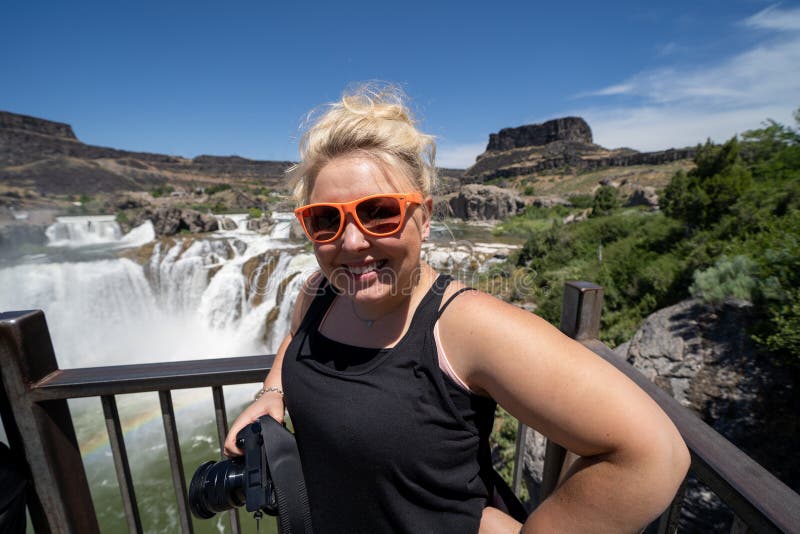 Blone young adult woman poses with her camera at the overlook of Shoshone Falls in Twin Falls Idaho royalty free stock image Blone young adult woman poses with her camera at the overlook of Shoshone Falls in Twin Falls Idaho royalty free stock image