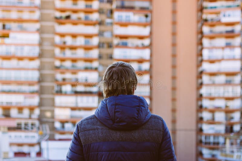 Blont mananseende på takterrass, tillbaka till kameralookinen royaltyfria bilder Blont mananseende på takterrass, tillbaka till kameralookinen royaltyfria bilder