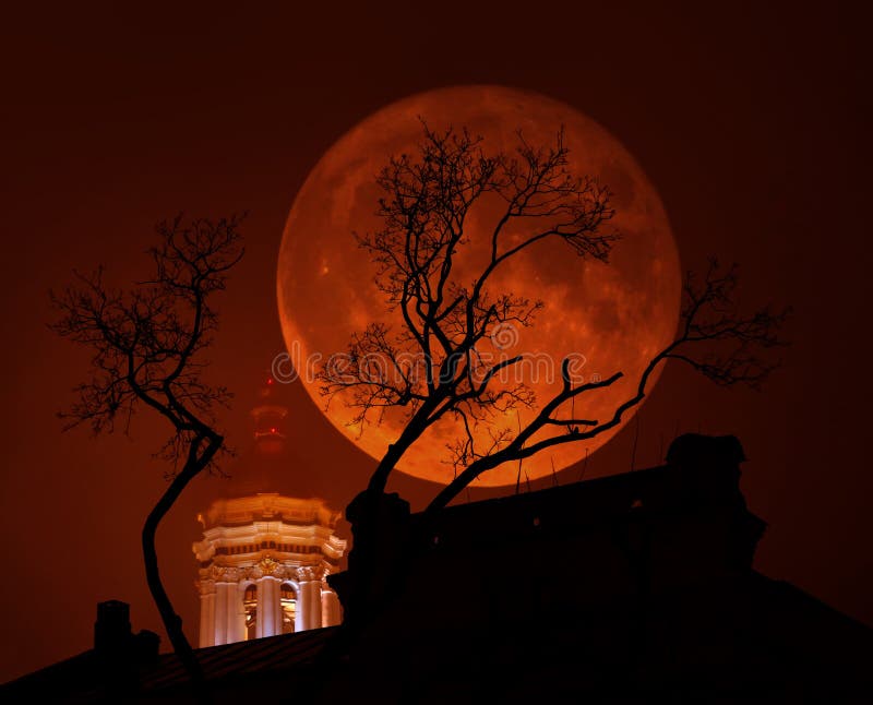 Blood-red Supermoon with a church and a tree in bad weather