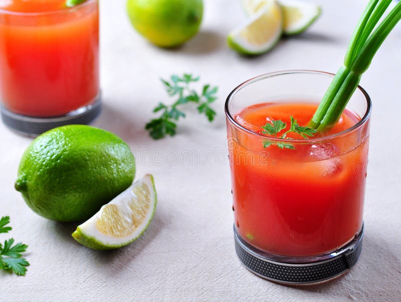 Bloody Mary cocktail in glasses-skull with celery sticks, pink salt, lime  and canapes from canned vegetables. Stock Photo by ©chudo2307 146601963