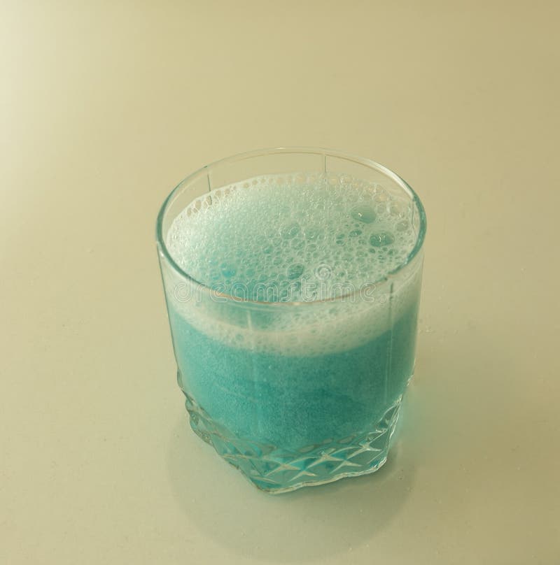 Blue Ale with Bubbles and Ice. Pouring the Drink in the Glass. Bright