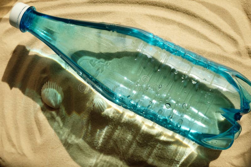 Blue Bottle of Water on Sandy Beach with Seashells. Summer, Vacation