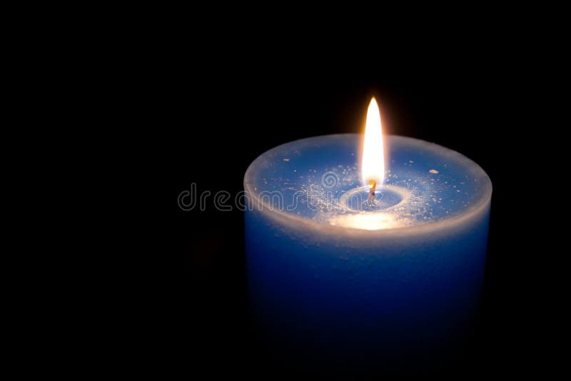 Blue candle burning in dark