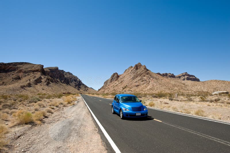 Modrý Chrysler PT Cruiser auto cestování na silnici procházející Údolím Oheň v blízkosti Las Vegas, USA.