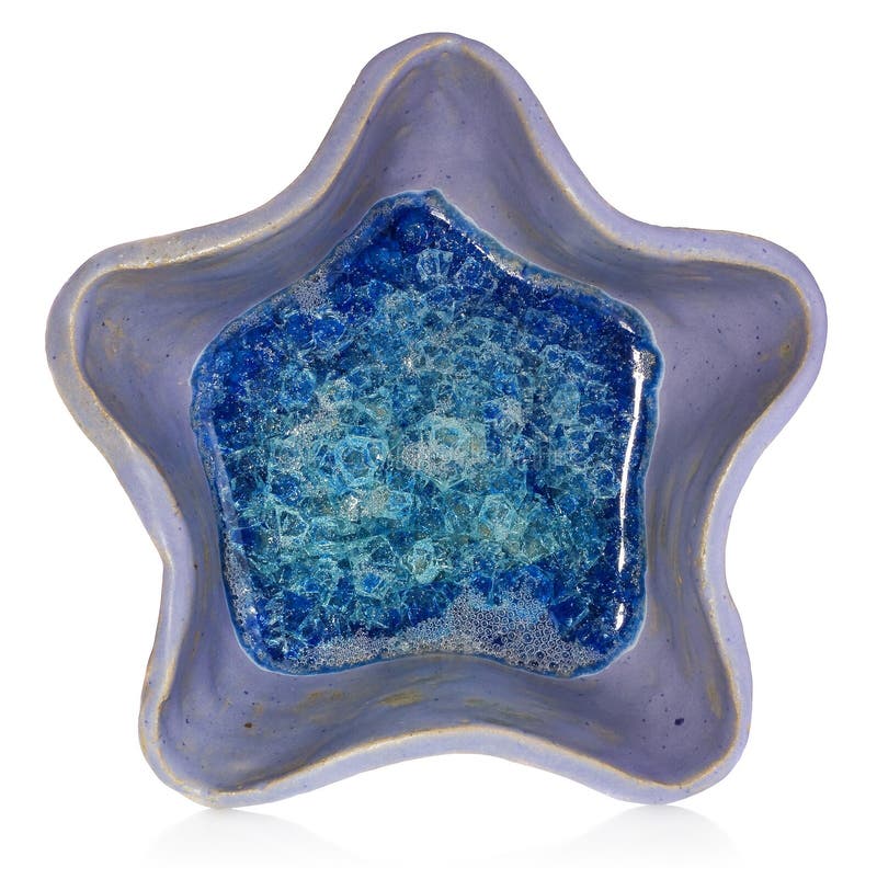 Blue, ceramic, handmade bowl in the shape of a star. At the bottom broken glass with bubbles of air.