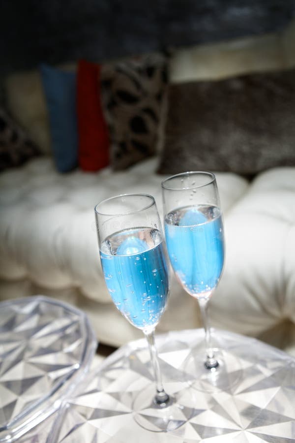 Two Blue Champagne Bottle with Confetti Stars on Light Blue Background ...